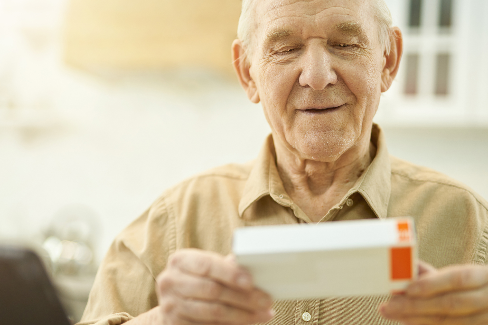 Attentive grandpa checking the name of his medication on box